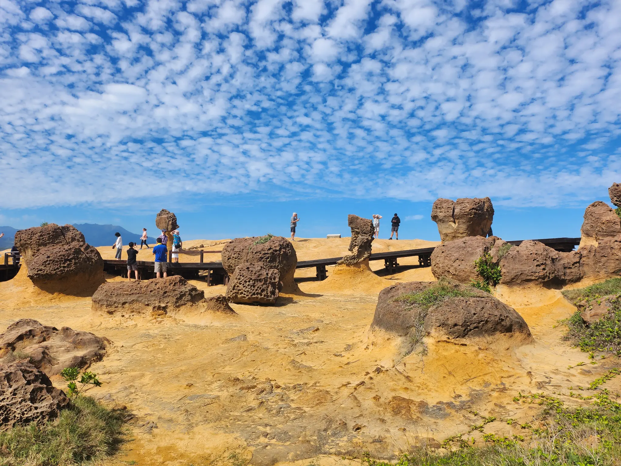 Coastal rock formations beneath a patterned blue sky